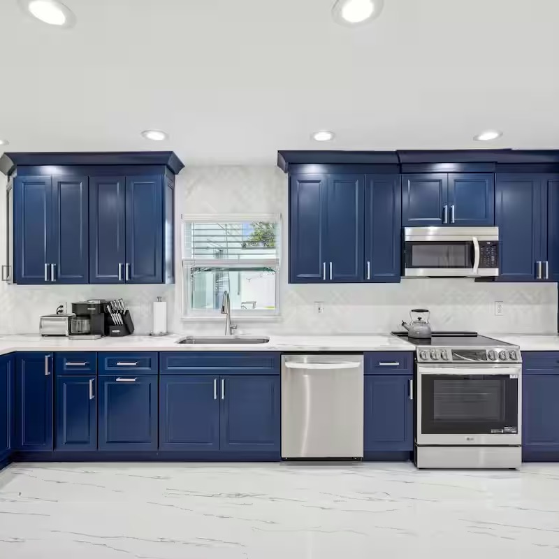 Kitchen remodel with navy blue cabinets and white countertops