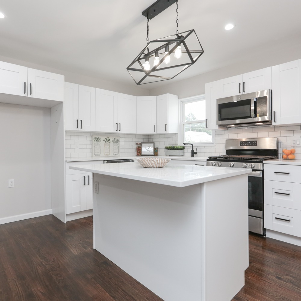 White kitchen remodel with subway tile and dark flooring